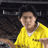 a young man wearing a yellow player jersey