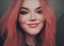 a close up of a woman 's face with red hair smiling .