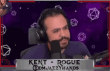 a man wearing headphones is sitting in front of a microphone and says kent rogue