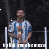 a man holding a trophy that says im not tryna be messi on it
