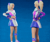 two cheerleaders are standing next to each other with their backs to the camera