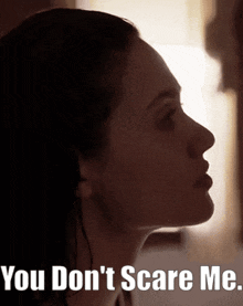 a close up of a woman 's face with the words " you don 't scare me " below it