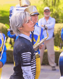 a man playing a saxophone in a marching band wearing a shirt that says ' a ' on it
