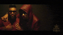 a couple of men are standing next to each other in a dark room .