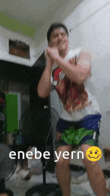 a man in shorts is dancing in a room with a fan .