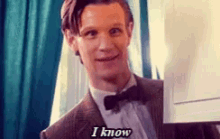 a man in a tuxedo and bow tie is holding a piece of paper and says `` i know '' .