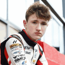 a young man is wearing a race suit with the word simex on the sleeve