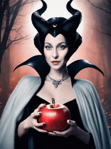 a woman with horns is holding a red apple in her hands