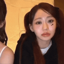 a woman with pigtails has a tattoo on her face that says ' i 'm sorry '