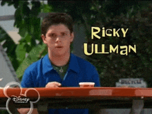 a young man sitting at a picnic table with the name ricky ullman on the screen