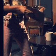 a man is standing in front of a table with a white cup on it