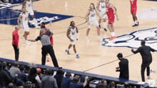 a group of basketball players are playing a game on a court and one of them is wearing number 14