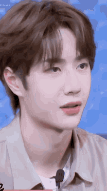 a close up of a young man 's face with a microphone