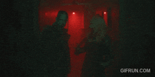 a gif from gifrun.com shows a man and a woman in a red room