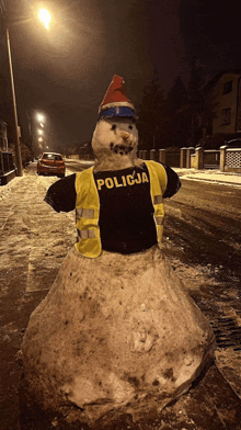 a snowman wearing a vest that says policja