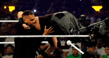 two wrestlers are wrestling in a wrestling ring .