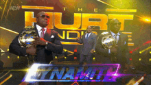 a man in a suit is holding a wrestling championship
