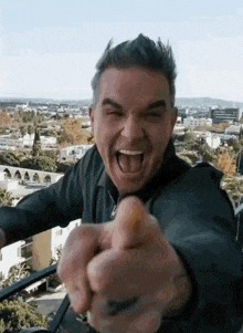 a man is pointing at the camera with his tongue out