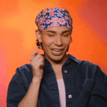 a man wearing a floral headband and a denim jacket