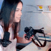 a woman is holding a canon camera in her hands