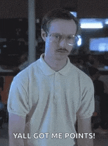 a man with glasses and a mustache is standing in a room and says `` yall got me points '' .