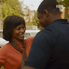 a man and a woman are standing next to each other and smiling for the camera .