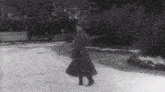 a black and white photo of a man walking in the snow .