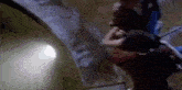a couple of people are standing next to each other in a tunnel .