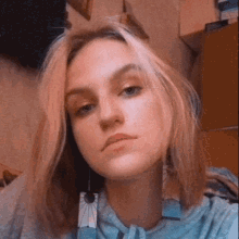 a young woman is taking a selfie with a pair of earrings hanging from her neck .