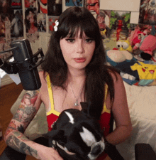a woman holds a dog in front of a microphone