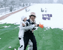 a couple of people standing in the snow with korean writing on the bottom