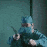 a surgeon wearing a mask is holding a knife .