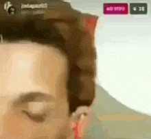a close up of a man 's face with his eyes closed in front of a sign that says no video