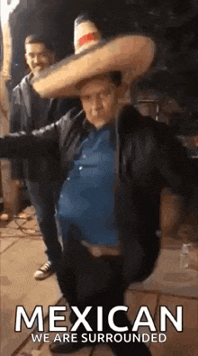 a man wearing a sombrero is dancing in front of a sign that says mexican we are surrounded