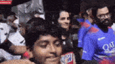 a man wearing a blue shirt that says qatar on it