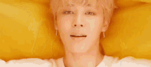 a close up of a person 's face with a yellow background and a smile .