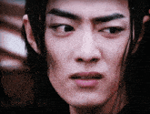 a close up of a man 's face with long hair and a serious look on his face