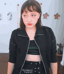 a woman wearing a black jacket that says " dynamite twins "