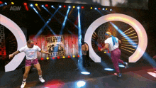 two men are dancing on a stage in front of a wanted poster