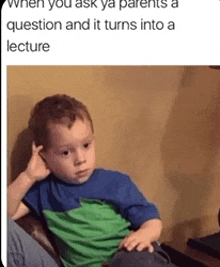 a little boy in a green and blue shirt is sitting on a couch thinking .
