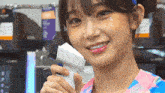 a girl with a rhinestone on her forehead is holding a white object