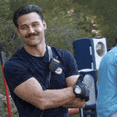 a man with a mustache wearing a watch and a walkie talkie around his neck