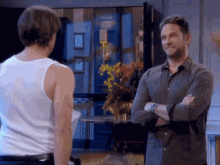 two men standing next to each other in a living room