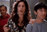 a woman with a surprised look on her face is standing next to a boy and a man