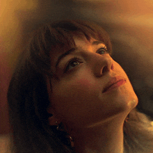 a close up of a woman 's face looking up at the sky