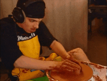 a man wearing headphones and a yellow apron with the word animal on it