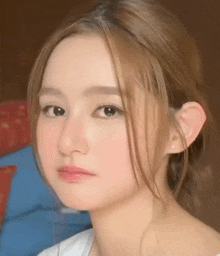 a close up of a woman 's face with her hair in a bun