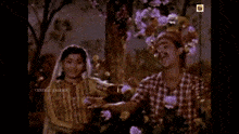 a man in a plaid shirt and a woman in a veil are dancing in front of a sign that says central talkies