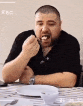 a man is sitting at a table with a plate of food and a watch on his wrist while eating food
