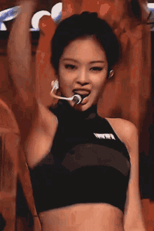 a woman wearing a crop top with a microphone on her head
